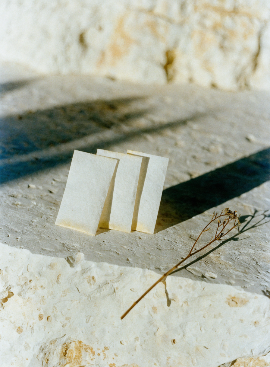 Fragrance blotter strips on a limestone ledge — sample on skin before committing to a full bottle